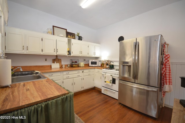 1409 E Walnut St, Goldsboro, NC 27530 - kitchen with white appliances, a sink, white cabinets, dark wood-style flooring, and butcher block countertops