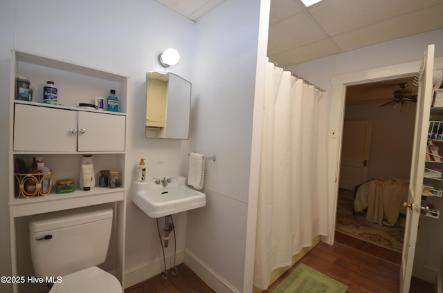1409 E Walnut St, Goldsboro, NC 27530 - bathroom with wood finished floors, toilet, a sink, and baseboards