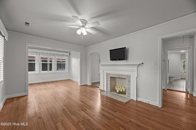 822 Chattawka Ln, New Bern, NC 28560 - unfurnished living room with ceiling fan, wood finished floors, a fireplace, baseboards, and arched walkways
