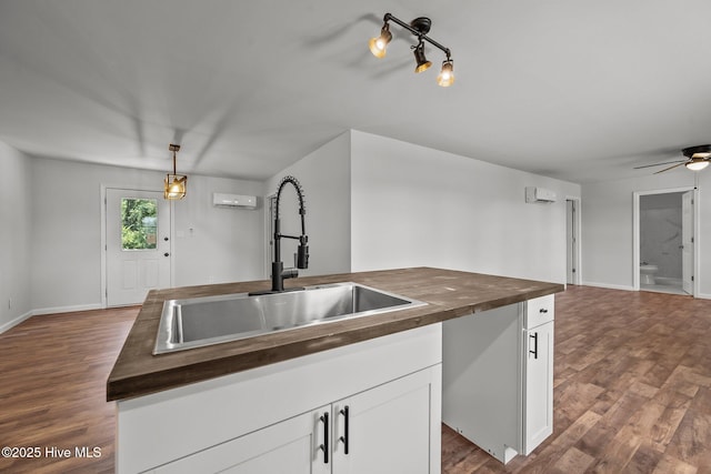 1496 Kellum Loop Rd, Jacksonville, NC 28546 - kitchen featuring butcher block counters, a sink, dark wood-type flooring, a ceiling fan, and white cabinets