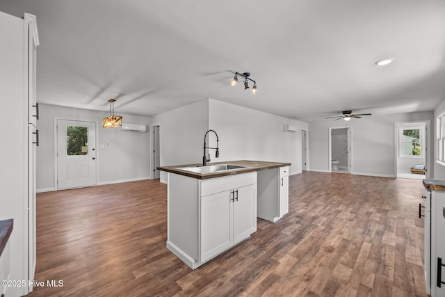 1496 Kellum Loop Rd, Jacksonville, NC 28546 - kitchen featuring a sink, open floor plan, a ceiling fan, a kitchen island with sink, and a wall mounted air conditioner