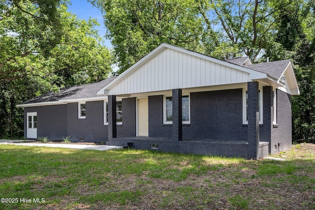 1496 Kellum Loop Rd, Jacksonville, NC 28546 - view of front facade with brick siding, crawl space, a shingled roof, a front lawn, and board and batten siding