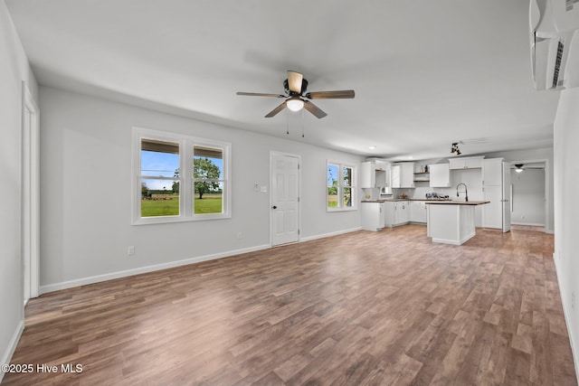 1496 Kellum Loop Rd, Jacksonville, NC 28546 - unfurnished living room with ceiling fan, light wood-type flooring, baseboards, and a sink