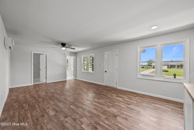 1496 Kellum Loop Rd, Jacksonville, NC 28546 - unfurnished living room with a ceiling fan, wood finished floors, baseboards, and a wall mounted AC