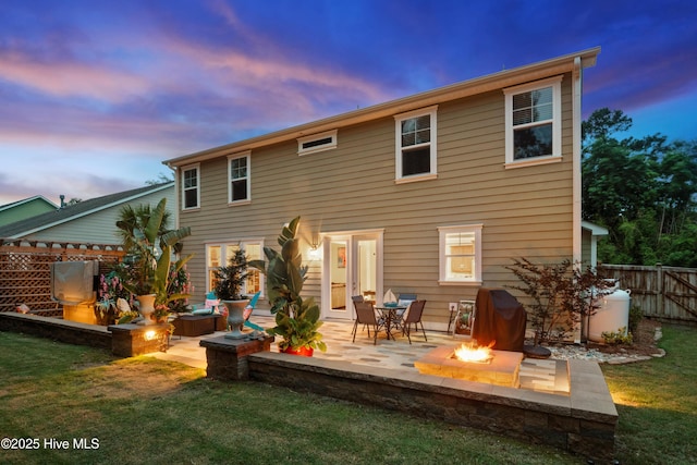 133 Overlook Dr, Wilmington, NC 28411 - back of property at dusk with a fire pit, a patio area, and a fenced backyard