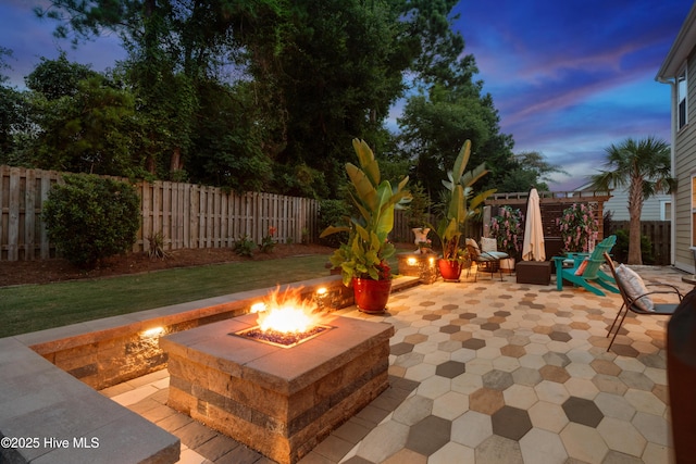 133 Overlook Dr, Wilmington, NC 28411 - patio terrace at dusk featuring a fire pit, a patio, and a fenced backyard