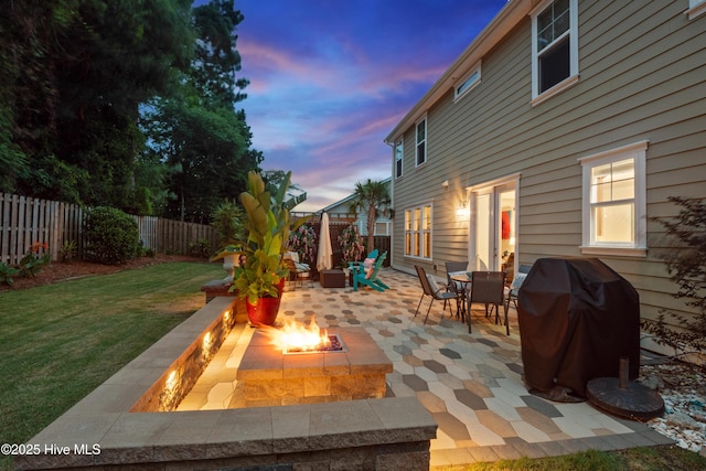 133 Overlook Dr, Wilmington, NC 28411 - patio terrace at dusk with a fire pit, grilling area, a fenced backyard, a patio, and outdoor dining area