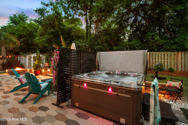 133 Overlook Dr, Wilmington, NC 28411 - fenced backyard with a hot tub, a fire pit, a patio, a storage unit, and view of scattered trees