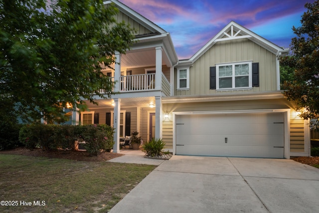 133 Overlook Dr, Wilmington, NC 28411 - view of front facade with board and batten siding, covered porch, a balcony, a garage, and driveway