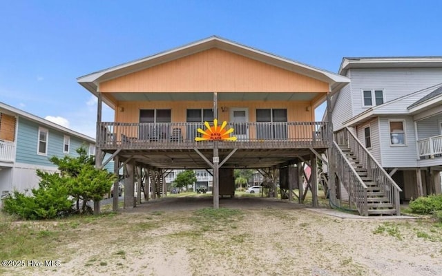 210 W Beach Dr, Oak Island, NC 28465 - coastal inspired home with driveway, a carport, stairs, and covered porch