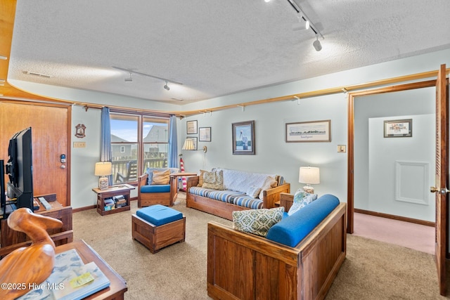 210 W Beach Dr, Oak Island, NC 28465 - carpeted living area featuring rail lighting and a textured ceiling