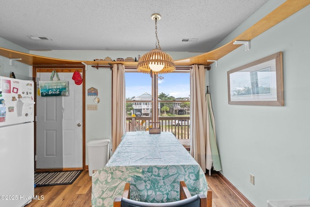 210 W Beach Dr, Oak Island, NC 28465 - dining room featuring a textured ceiling and wood finished floors