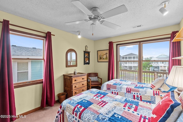 210 W Beach Dr, Oak Island, NC 28465 - bedroom with light carpet, a textured ceiling, and ceiling fan