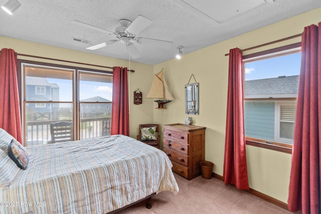210 W Beach Dr, Oak Island, NC 28465 - bedroom featuring carpet floors, a textured ceiling, and a ceiling fan