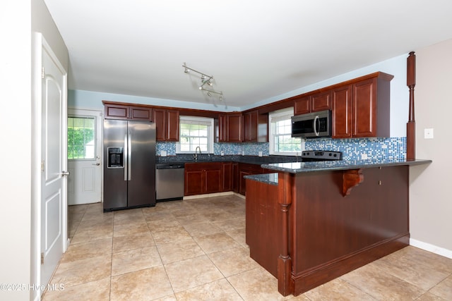 4173 Middle Rd, Trenton, NC 28585 - kitchen featuring appliances with stainless steel finishes, decorative backsplash, a peninsula, a breakfast bar area, and light tile patterned floors