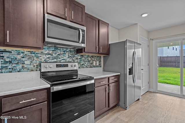 694 Chester Way NE, Leland, NC 28451 - kitchen featuring appliances with stainless steel finishes, dark brown cabinetry, backsplash, and light wood finished floors