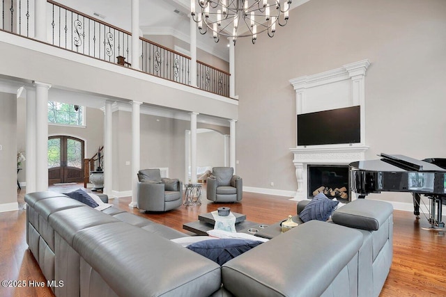 2270 Midland Rd, Pinehurst, NC 28374 - living area featuring a towering ceiling, a chandelier, ornate columns, wood finished floors, and crown molding