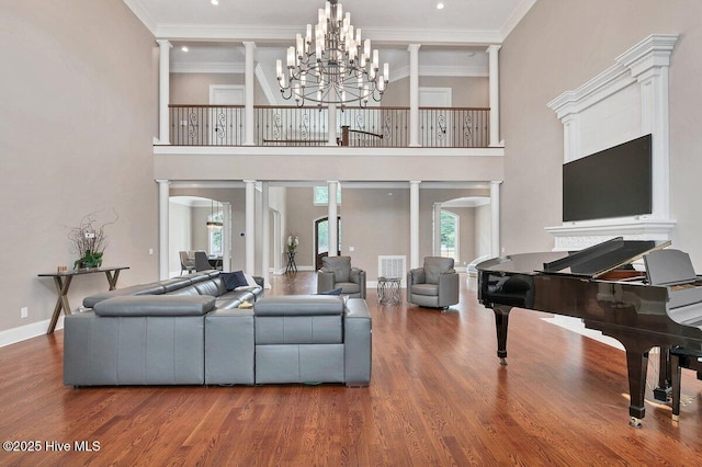 2270 Midland Rd, Pinehurst, NC 28374 - living area with arched walkways, wood finished floors, ornate columns, a towering ceiling, and crown molding