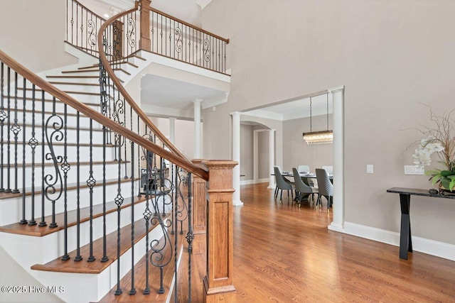 2270 Midland Rd, Pinehurst, NC 28374 - stairs featuring a towering ceiling, wood finished floors, ornamental molding, and arched walkways