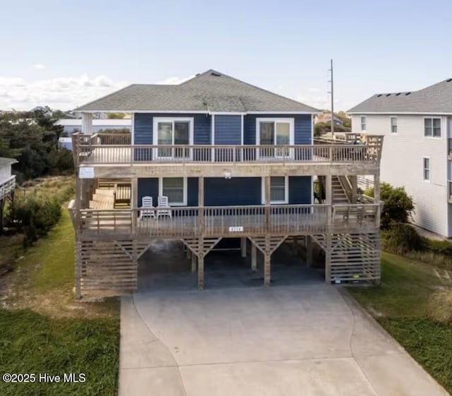 4704 S Va Dare Trl, Nags Head, NC 27959 - coastal inspired home with a carport, stairway, driveway, and a wooden deck
