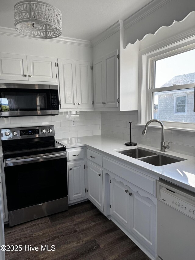 4704 S Va Dare Trl, Nags Head, NC 27959 - kitchen featuring appliances with stainless steel finishes, ornamental molding, backsplash, light countertops, and white cabinets