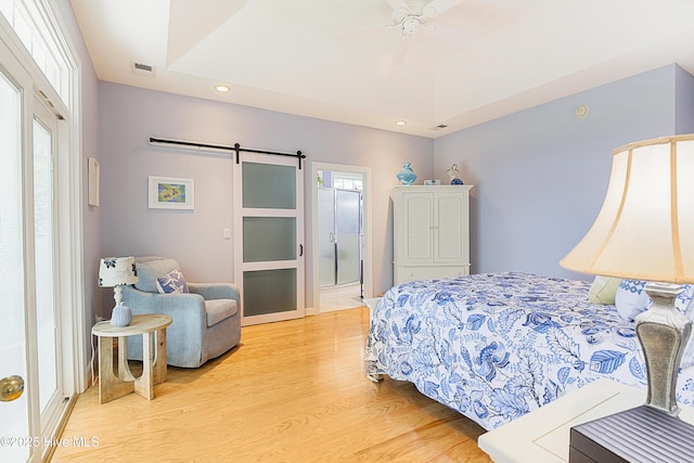 1209 Moultrie Dr NW, Calabash, NC 28467 - bedroom featuring a barn door, light wood-style flooring, multiple windows, recessed lighting, and a ceiling fan