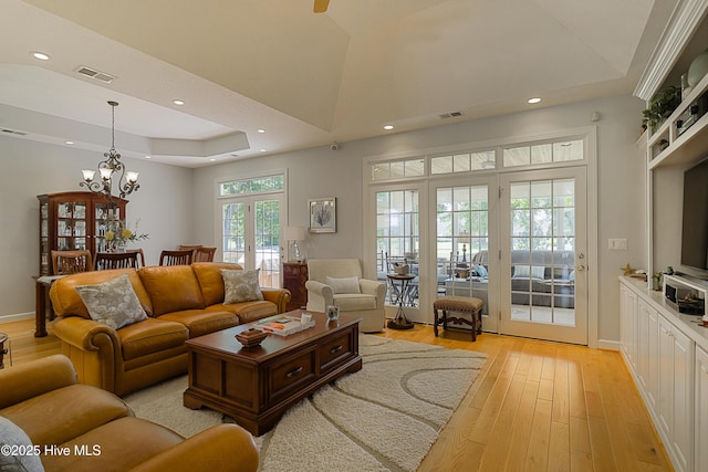 1209 Moultrie Dr NW, Calabash, NC 28467 - living area with light wood-style floors, a tray ceiling, recessed lighting, a chandelier, and french doors