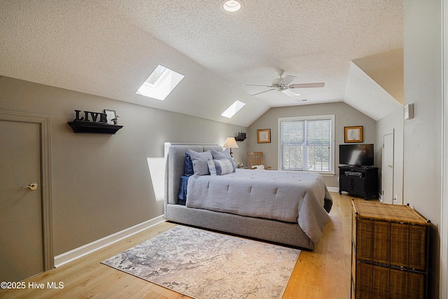 1209 Moultrie Dr NW, Calabash, NC 28467 - bedroom featuring a skylight, a textured ceiling, light wood-style floors, lofted ceiling, and baseboards