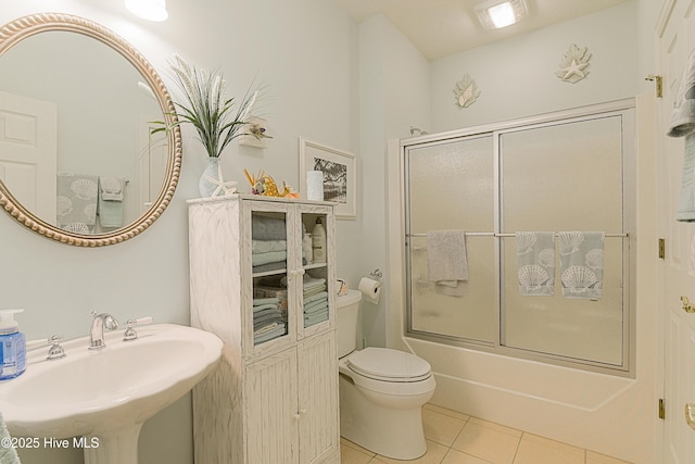 1209 Moultrie Dr NW, Calabash, NC 28467 - bathroom with a sink, tile patterned flooring, toilet, and bath / shower combo with glass door
