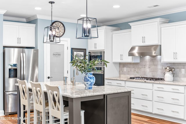 8116 Barstow Ln, Wilmington, NC 28411 - kitchen with appliances with stainless steel finishes, under cabinet range hood, white cabinets, crown molding, and recessed lighting