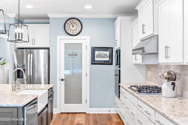 8116 Barstow Ln, Wilmington, NC 28411 - kitchen with appliances with stainless steel finishes, under cabinet range hood, white cabinets, backsplash, and crown molding