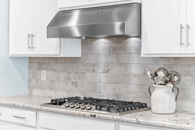 8116 Barstow Ln, Wilmington, NC 28411 - kitchen featuring wall chimney range hood, stainless steel gas cooktop, white cabinets, and decorative backsplash