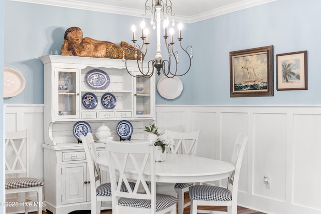 8116 Barstow Ln, Wilmington, NC 28411 - dining room with a decorative wall, a chandelier, a wainscoted wall, and ornamental molding