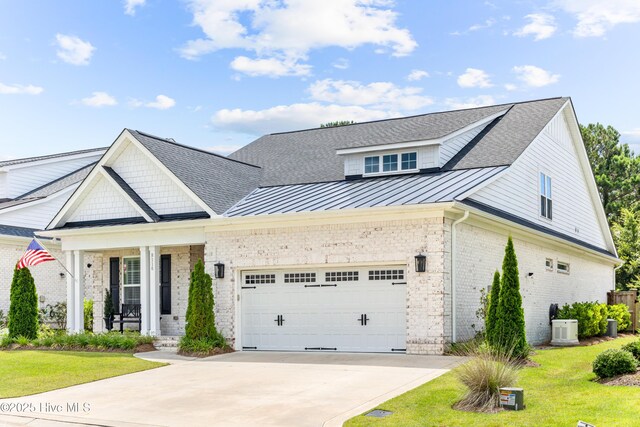 8116 Barstow Ln, Wilmington, NC 28411 - view of front of home with brick siding, a standing seam roof, an attached garage, driveway, and a front yard