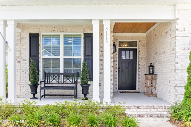 8116 Barstow Ln, Wilmington, NC 28411 - doorway to property with a porch and brick siding