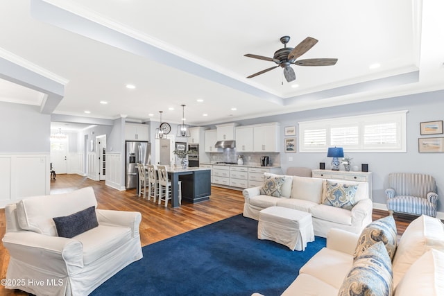 8116 Barstow Ln, Wilmington, NC 28411 - living area with ceiling fan, ornamental molding, wood finished floors, recessed lighting, and a tray ceiling