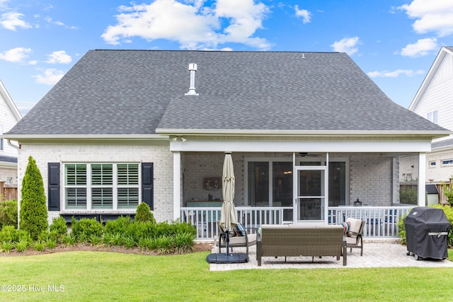 8116 Barstow Ln, Wilmington, NC 28411 - rear view of house featuring a lawn, a shingled roof, brick siding, and an outdoor hangout area