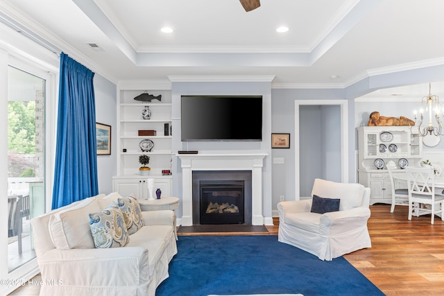 8116 Barstow Ln, Wilmington, NC 28411 - living area featuring wood finished floors, a tray ceiling, a glass covered fireplace, and crown molding