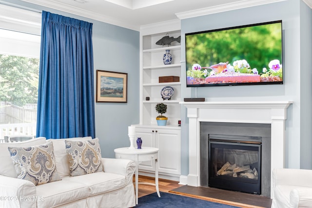 8116 Barstow Ln, Wilmington, NC 28411 - living area featuring wood finished floors, crown molding, built in shelves, and a glass covered fireplace