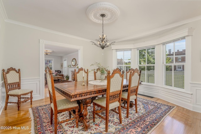 405 Hancock St, New Bern, NC 28560 - dining space with a chandelier, light wood finished floors, crown molding, and wainscoting