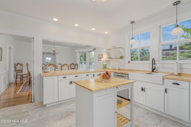 405 Hancock St, New Bern, NC 28560 - kitchen featuring butcher block counters, a sink, crown molding, light marble finish floors, and white cabinetry