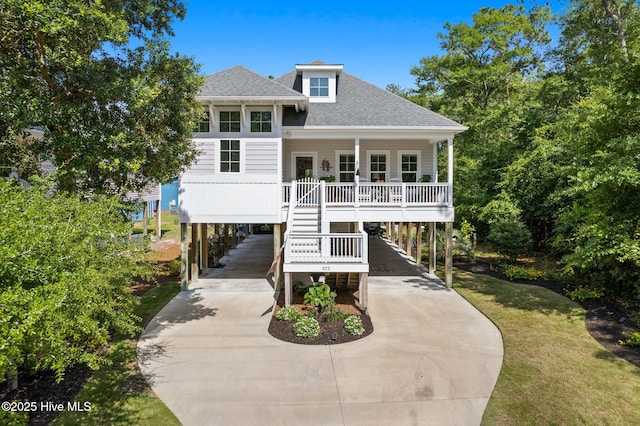 322 NE 42nd St, Oak Island, NC 28465 - beach home with a carport, a shingled roof, concrete driveway, a porch, and stairway