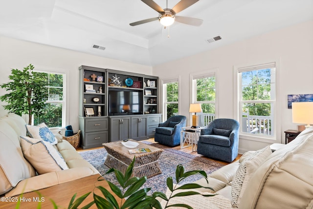 322 NE 42nd St, Oak Island, NC 28465 - living room with plenty of natural light, ceiling fan, a raised ceiling, and wood finished floors