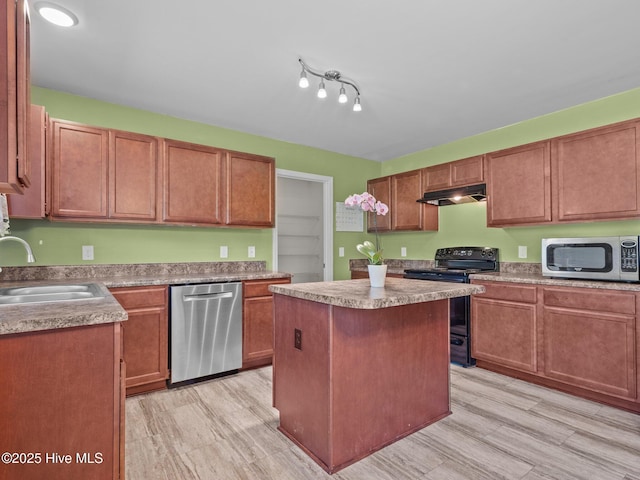301 Stella Bridgeway Dr, Stella, NC 28582 - kitchen with stainless steel appliances, under cabinet range hood, a center island, light wood-style floors, and light countertops