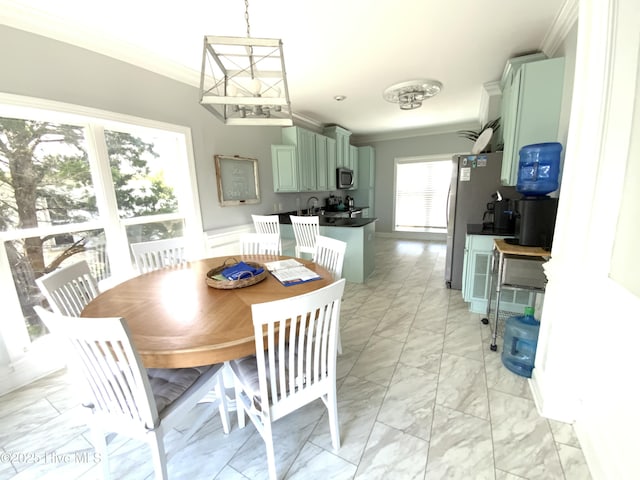2911 E Pelican Dr, Oak Island, NC 28465 - dining area featuring ornamental molding, light marble finish flooring, and a chandelier