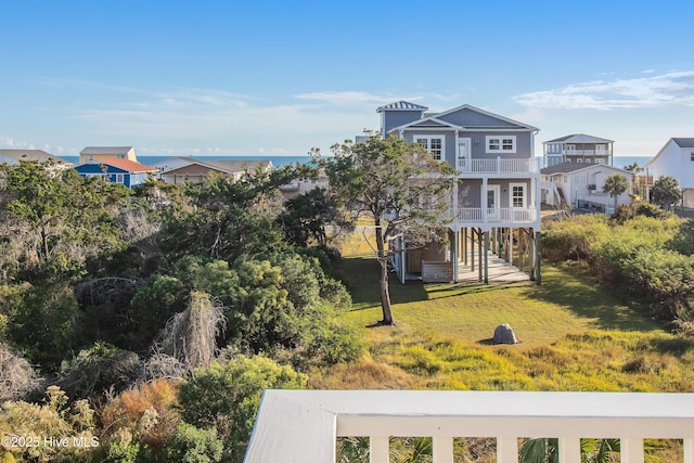 2911 E Pelican Dr, Oak Island, NC 28465 - rear view of house featuring a balcony, stairway, and a yard