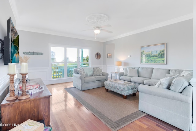 2911 E Pelican Dr, Oak Island, NC 28465 - living area with crown molding, a ceiling fan, a wainscoted wall, and wood finished floors