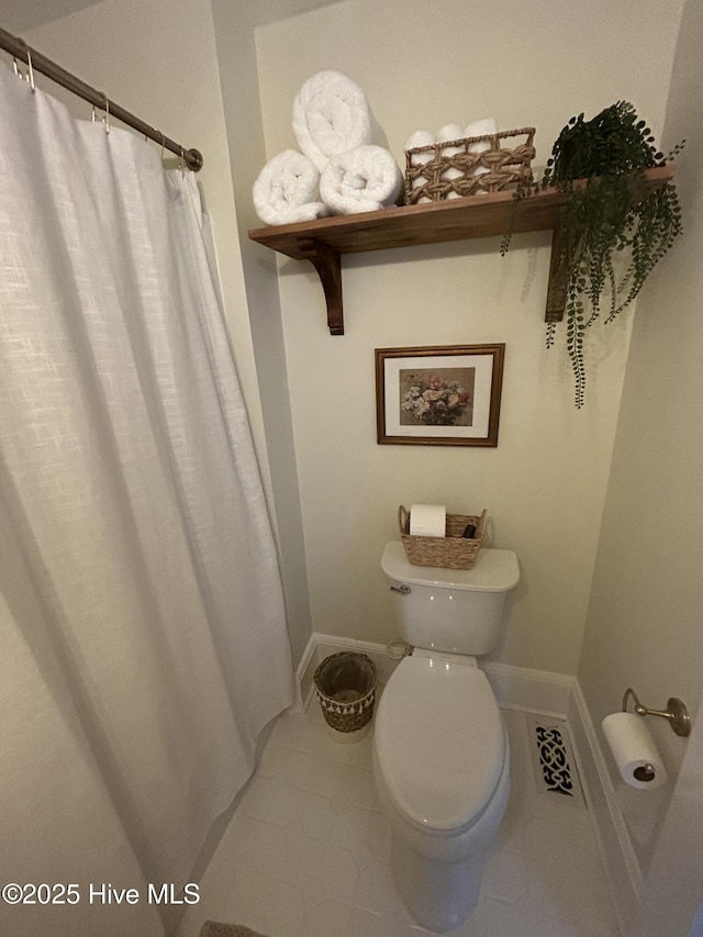 750 W 2nd St, Washington, NC 27889 - bathroom with tile patterned floors, toilet, baseboards, and a shower with shower curtain