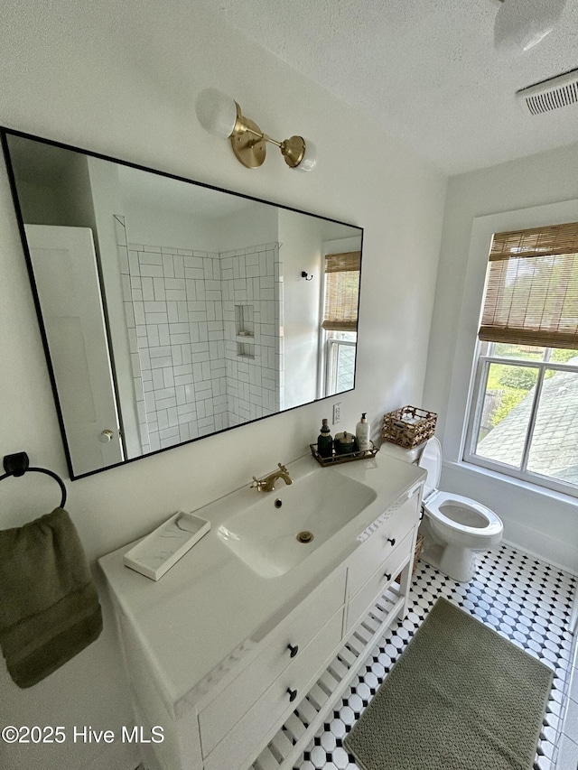 750 W 2nd St, Washington, NC 27889 - bathroom featuring a textured ceiling, toilet, vanity, tile patterned floors, and a shower