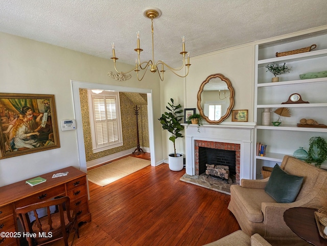 750 W 2nd St, Washington, NC 27889 - living area featuring hardwood / wood-style flooring, a textured ceiling, a fireplace, a chandelier, and baseboards